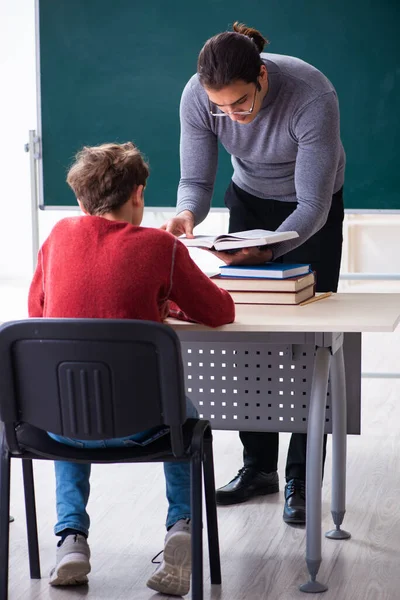 Jonge mannelijke leraar en schooljongen in de klas — Stockfoto