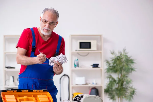 Öreg férfi vállalkozó javítás légkondicionáló beltéri — Stock Fotó