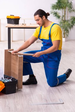 Genç erkek marangoz içeride çalışıyor.