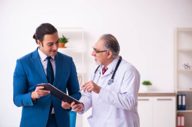 Genç işadamı yaşlı doktorla görüşüyor.