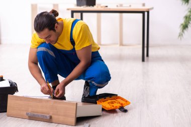 Genç erkek marangoz içeride çalışıyor.