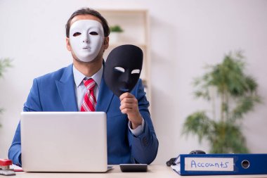 İkiyüzlülük konseptinde maske takan erkek çalışan.