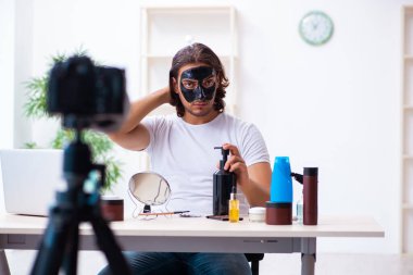 Genç erkek kozmetikçi blogu için video kaydediyor.