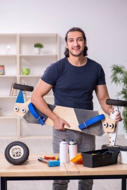 Kaykay tamir eden genç bir erkek tamirci.