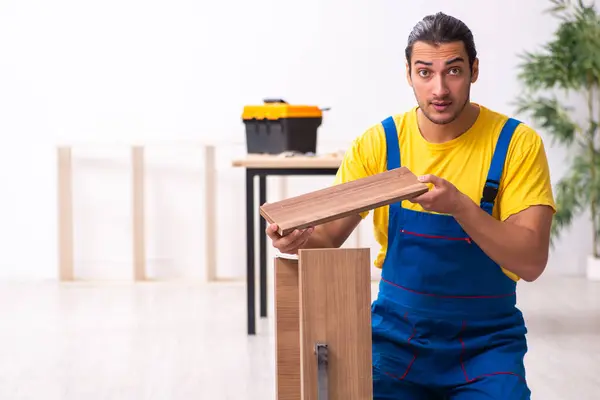 Jovem carpinteiro do sexo masculino trabalhando dentro de casa — Fotografia de Stock