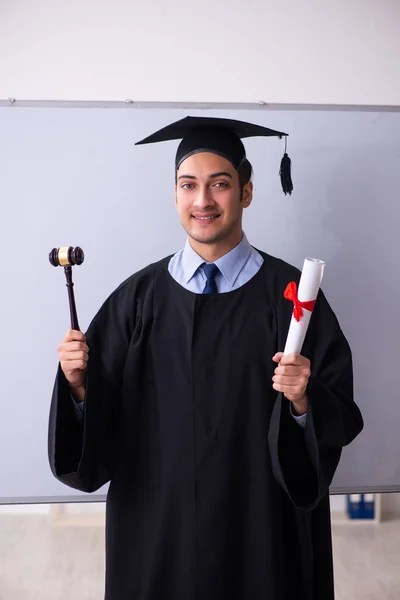 Young male graduate in front of board — Stock Photo, Image