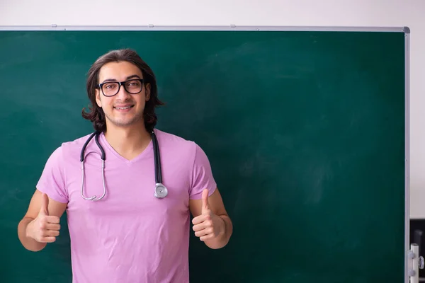 Jonge mannelijke student voor het bestuur — Stockfoto