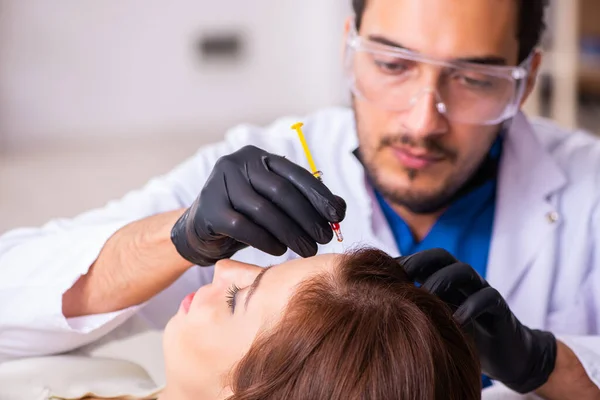 Mujer joven visitando a esteticista masculino en trasplante de cabello con — Foto de Stock