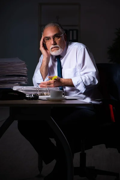 Viejo empleado trabajando hasta tarde en el lugar de trabajo — Foto de Stock