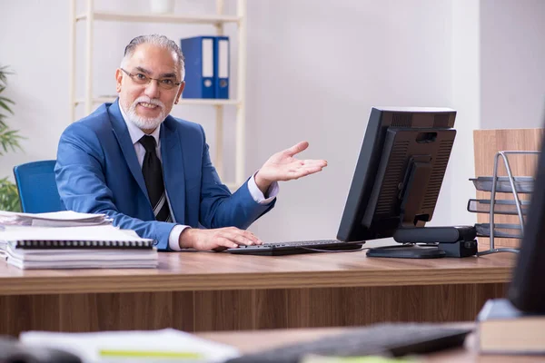 Alte männliche Mitarbeiter und exzessive Arbeit im Büro — Stockfoto