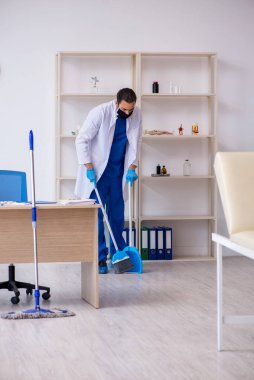 Genç erkek müteahhit salgın konseptinde dezenfekte kliniği