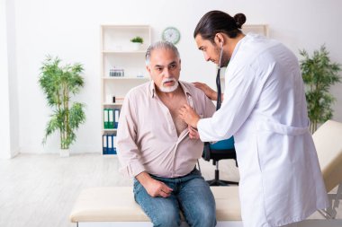 Yaşlı adam genç doktor kardiyoloğu ziyaret ediyor.