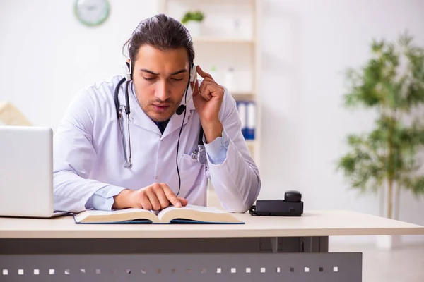 Junger Arzt hört Patient während telemedizinischer Sitzung zu — Stockfoto