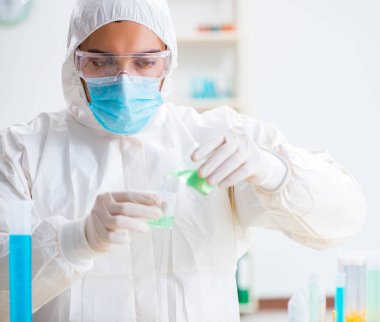 Laboratuvarda kimyasallar üzerinde çalışan genç bir kimyager.