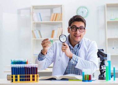 Laboratuvarda kimyasallar üzerinde çalışan genç bir kimyager.