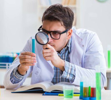 Laboratuvarda kimyasallar üzerinde çalışan genç bir kimyager.