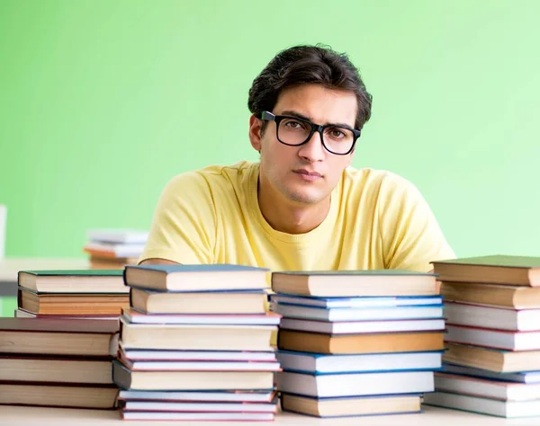 Студент, у которого слишком много книг, чтобы их прочитать перед экзаменом — стоковое фото