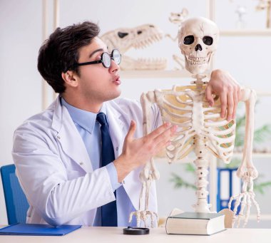 Çılgın profesör insan iskeleti üzerinde çalışıyor.