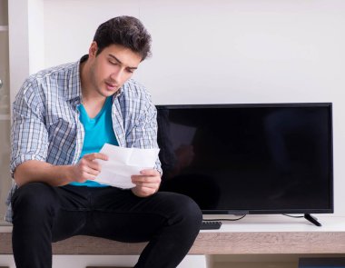 Bozuk televizyonu tamir etmeye çalışan adam