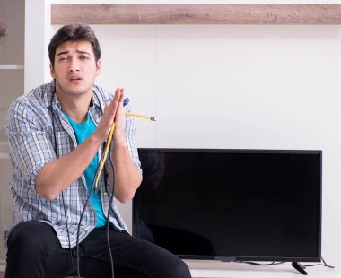 Bozuk televizyonu tamir etmeye çalışan adam