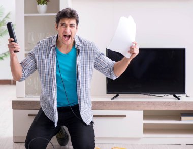 Bozuk televizyonu tamir etmeye çalışan adam