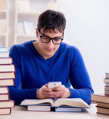 Erkek öğrenci üniversite kütüphanesinde sınava hazırlanıyor.