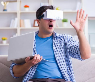 Evde sanal gerçeklik gözlükleriyle serbest çalışan bir öğrenci.