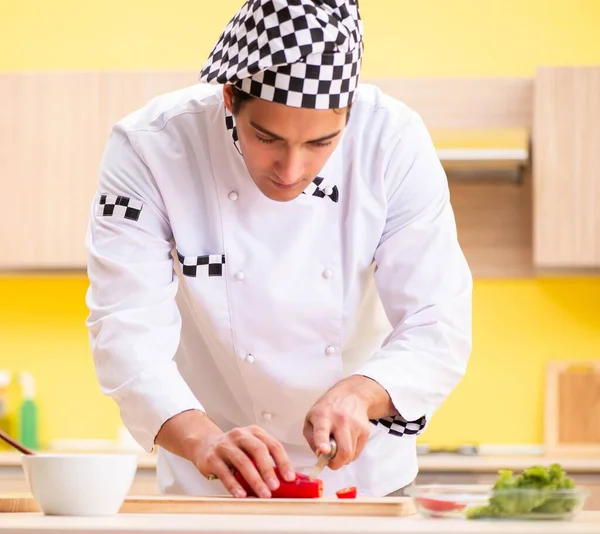 Joven cocinero profesional preparando ensalada en casa — Foto de Stock