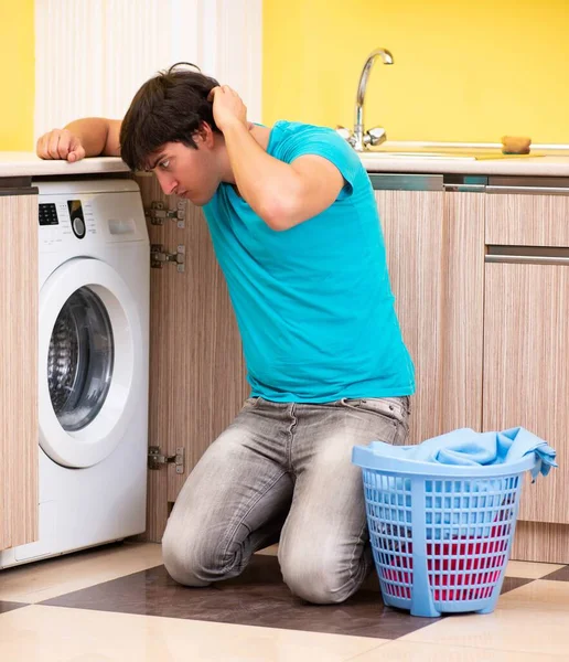 Молодой муж стирает дома. — стоковое фото
