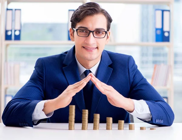 Businessman with stacks of coins in the office — Stock Photo, Image