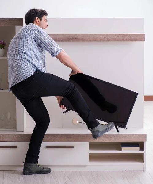 Bozuk televizyonu tamir etmeye çalışan adam