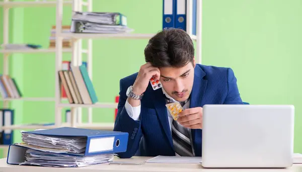 Επιχειρηματίας δυσαρεστημένος με την υπερβολική εργασία κάθεται στο γραφείο — Φωτογραφία Αρχείου