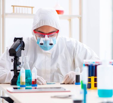 Laboratuvarda kimyasallar üzerinde çalışan genç bir kimyager.