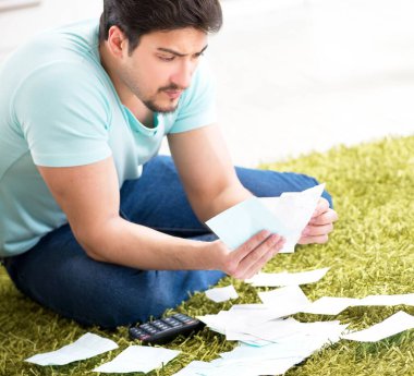 Genç adam kişisel finans ve faturalarla boğuşuyor.