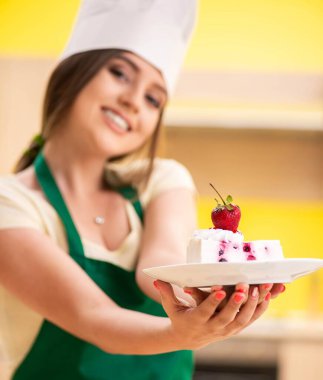 Genç aşçı mutfakta kek pişiriyor.