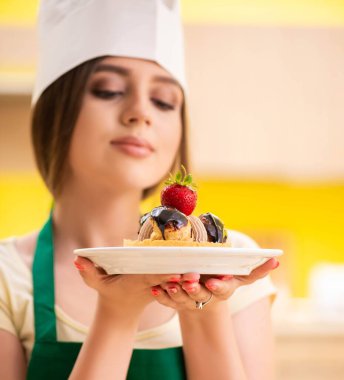 Genç aşçı mutfakta kek pişiriyor.