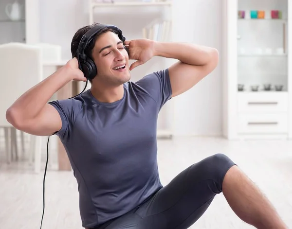 Adam evde spor yapıyor ve müzik dinliyor. — Stok fotoğraf