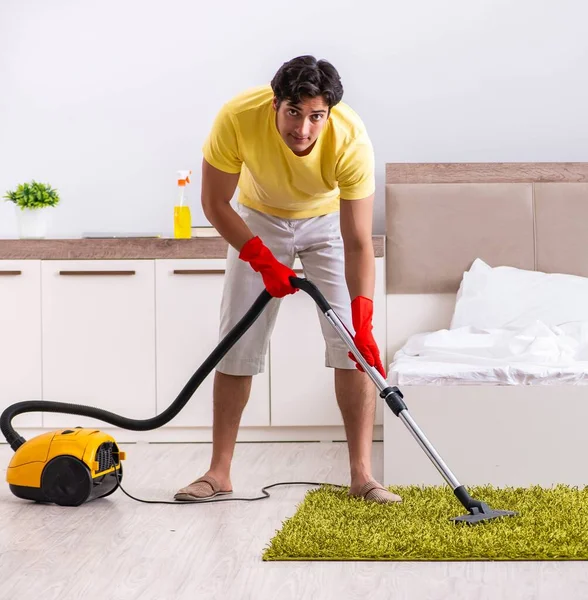 Young handsome man cleaning in the bedroom — Stock Photo, Image