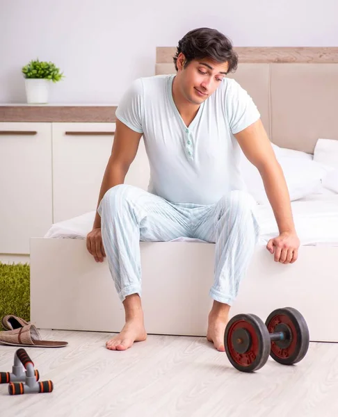 Jongeman doet ochtendroutine in de slaapkamer — Stockfoto