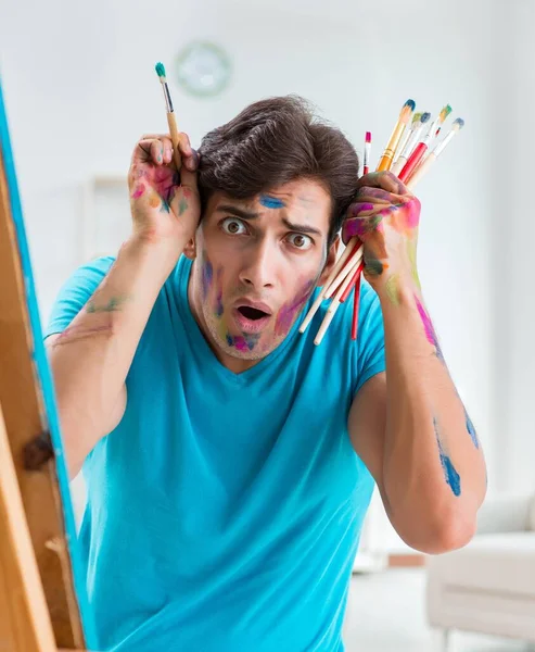 Joven artista divertido trabajando en la nueva pintura en su estudio — Foto de Stock