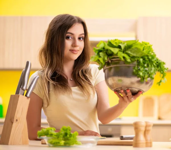 Mujer joven preparando ensalada en casa en la cocina —  Fotos de Stock