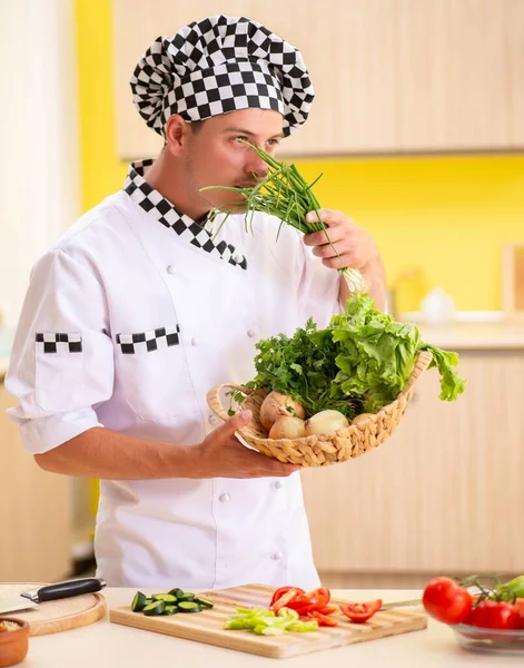 Молодой профессиональный повар готовит салат на кухне — стоковое фото