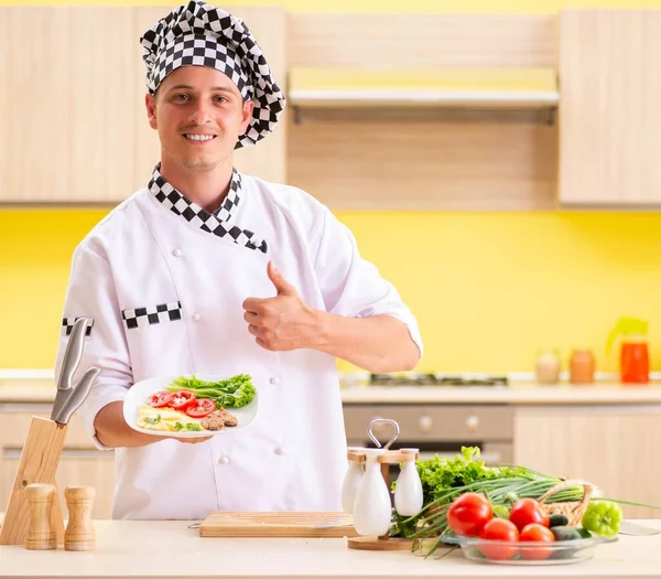 Joven cocinero profesional preparando ensalada en la cocina —  Fotos de Stock