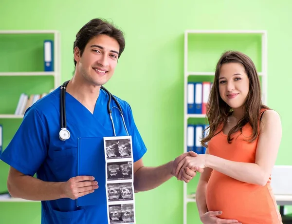 Беременная женщина, посещающая мужского гинеколога в клинике — стоковое фото