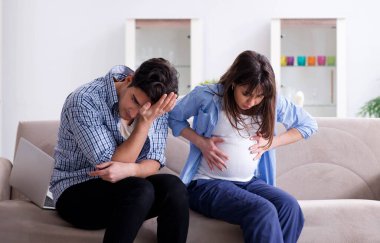 Evde kocası olan hamile bir kadın.