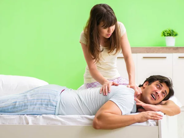 Mulher fazendo massagem ao marido no quarto — Fotografia de Stock