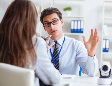 Mağazadaki müşteriye kamera gösteren satış asistanı