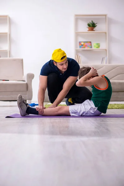 Pai e filho fazendo exercícios esportivos dentro de casa — Fotografia de Stock