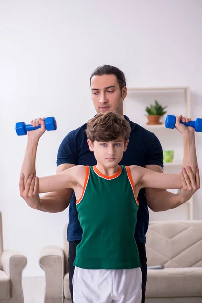Isä ja poika harrastavat urheilua sisätiloissa — kuvapankkivalokuva