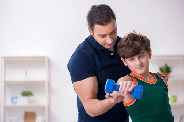 Pai e filho fazendo exercícios esportivos dentro de casa — Fotografia de Stock